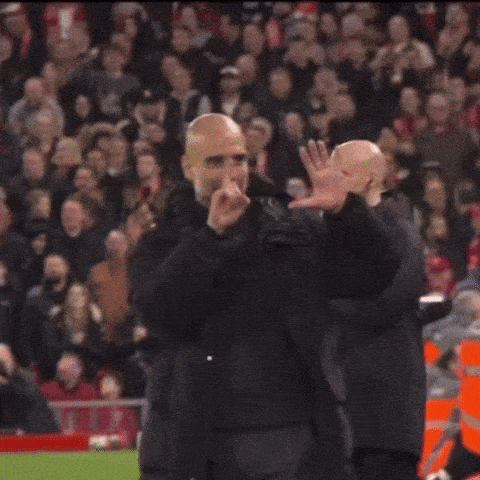 two bald men are standing in front of a crowd of people