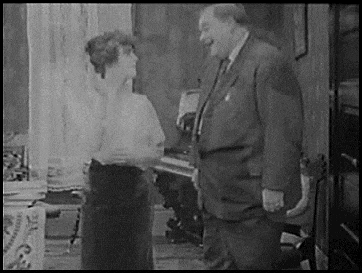 a man and a woman are standing next to each other in a room .