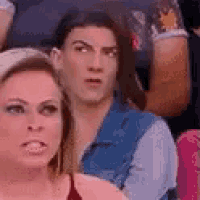 a man and a woman are sitting in a stadium .