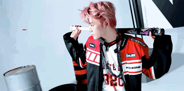 a young man with pink hair is holding a bat over his shoulder and wearing a nozone shirt