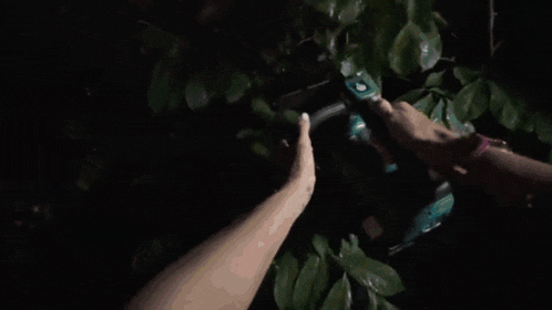 a woman in a pink tank top is holding a chainsaw that says makita