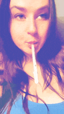 a woman in a blue shirt is holding a lollipop