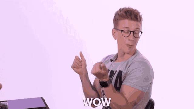 a man wearing glasses and a watch is giving a thumbs up and saying wow