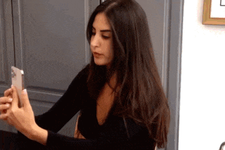 a woman is taking a picture of herself with her cell phone