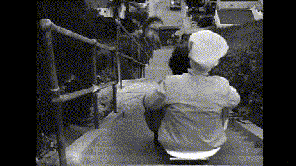 a black and white photo of a man sitting on a skateboard