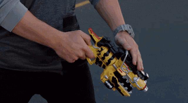 a man wearing a hat is holding a toy gun