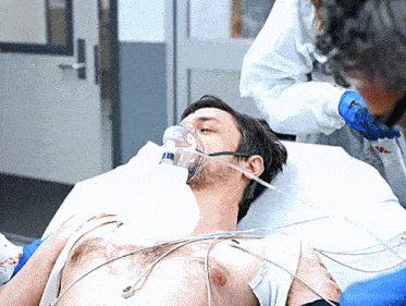 a man in a hospital bed with an oxygen mask on