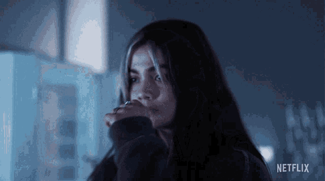 a woman in a dark room with a netflix logo on the bottom right