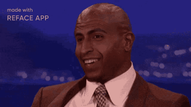 a man in a suit and tie is smiling with the words made with reface app above him