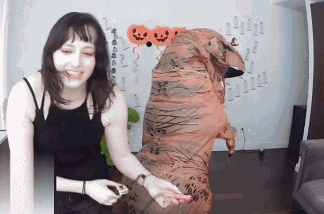 a woman in a t-rex costume stands next to another woman