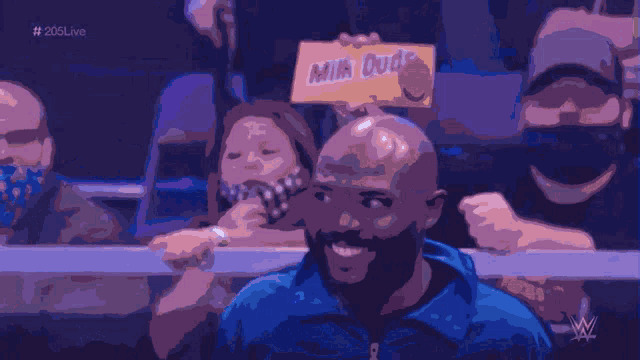 a man holding a sign that says milk dud