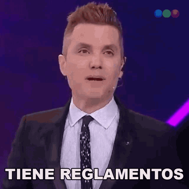 a man in a suit and tie is saying " tiene reglamentos "