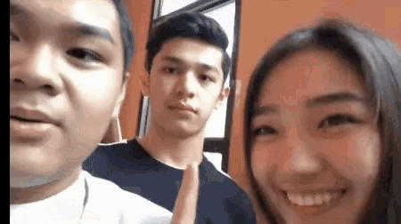 a man and a woman are posing for a picture together and the woman is smiling .