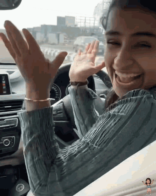 a woman sitting in a car with her hands up