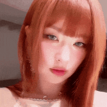 a close up of a woman 's face with red hair