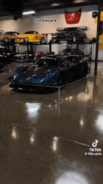a blue sports car is displayed in a garage .