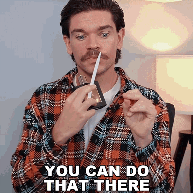 a man in a plaid shirt is holding a pen and saying you can do that there