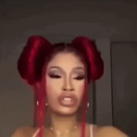 a close up of a woman 's face with red hair in two buns .