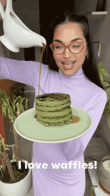 a woman pouring syrup on a stack of waffles with the words " i love waffles " on the bottom