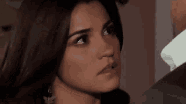 a close up of a woman 's face with a man 's arm around her shoulder .