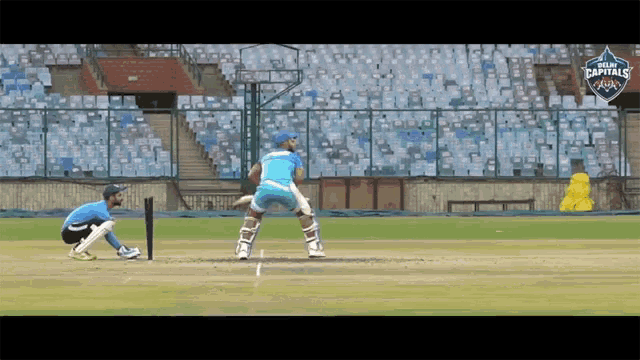 a cricket game is being played in a stadium that has the word capitals on it