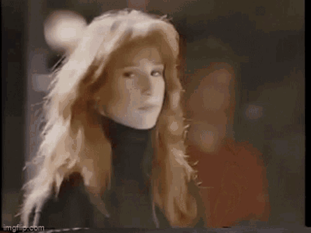 a woman with long red hair is wearing a black turtleneck .