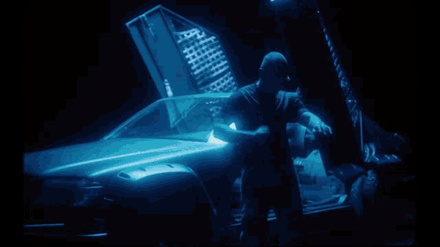 a man is standing in front of a car that has the hood open