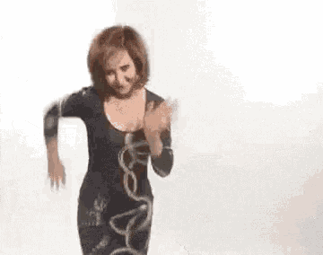 a woman in a black dress is dancing in a room .