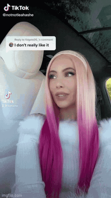a woman with pink hair is sitting in the back seat of a car with a comment that says i don 't really like it