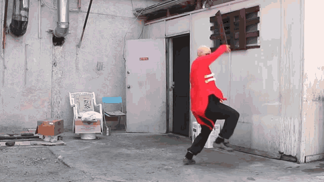 a man in a red jacket is dancing in front of a door that says no entry