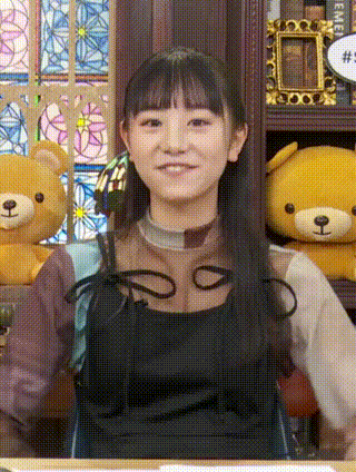a girl is standing in front of a shelf with teddy bears .