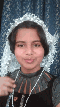 a little girl wearing a black dress and a white lace hat
