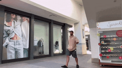 a man stands in front of a sprinkles candy machine