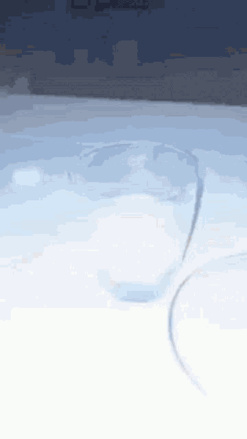 a glass of water is sitting on a table with a blue background
