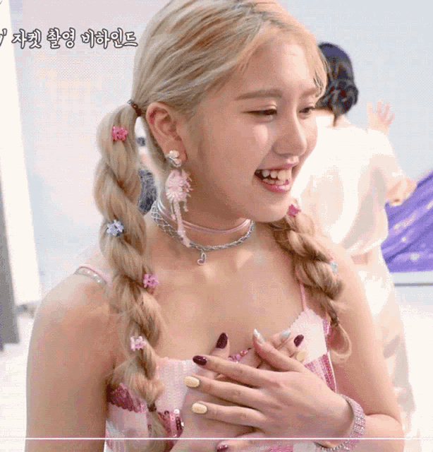a woman wearing a braided ponytail and a choker necklace smiles