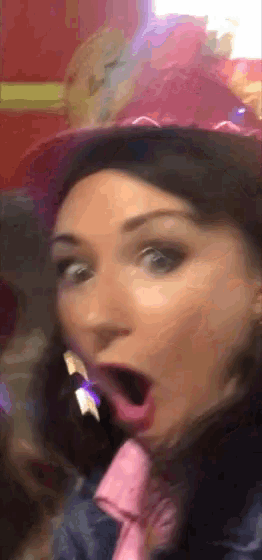 a woman wearing a pink hat and a pink tie is making a surprised face