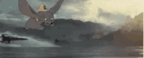 dumbo the elephant is flying over a body of water with a crown on his head .