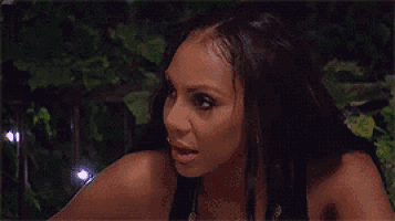a woman with long black hair is making a funny face .