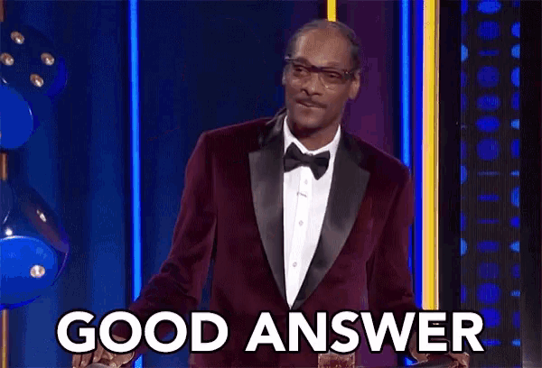snoop dogg is wearing a tuxedo and bow tie and says `` good answer '' while standing on a stage .