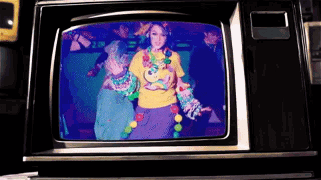a woman in a yellow shirt is dancing on a television