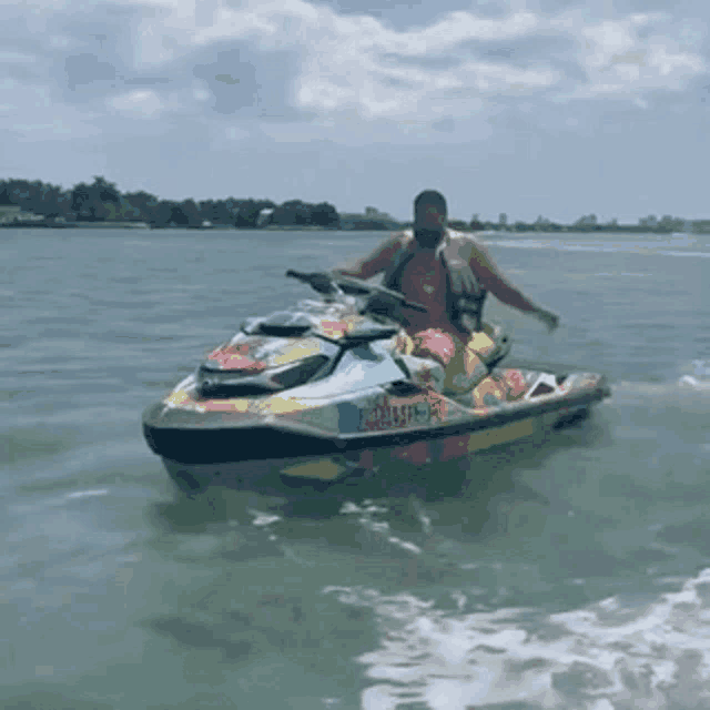 a man is riding a colorful jet ski in the water with a license plate that says rcl59-p