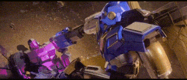 a blue robot and a purple robot are fighting each other .