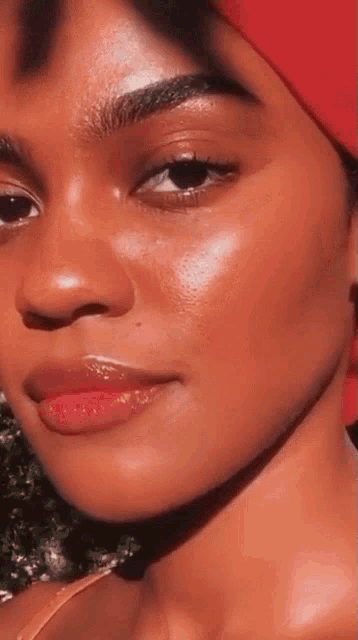 a close up of a woman 's face with a red scarf around her head