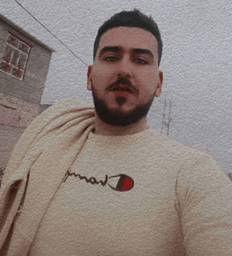 a man with a beard wears a champion t-shirt