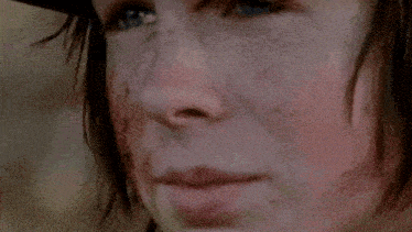 a close up of a person 's face wearing a cowboy hat and looking down .