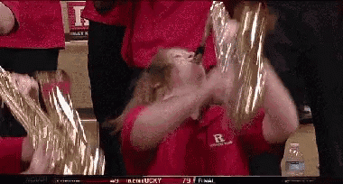 a woman in a red shirt with the letter r on it is playing a saxophone
