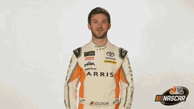 a man in a nascar uniform is standing with his hands outstretched