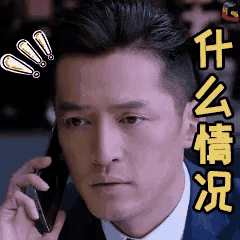 a man in a suit is talking on a cell phone with chinese writing on his face .
