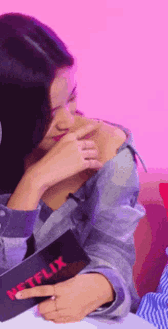 a woman is sitting at a table with a netflix magazine in front of her
