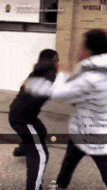 a snapchat of two people fighting with the name howard at the bottom